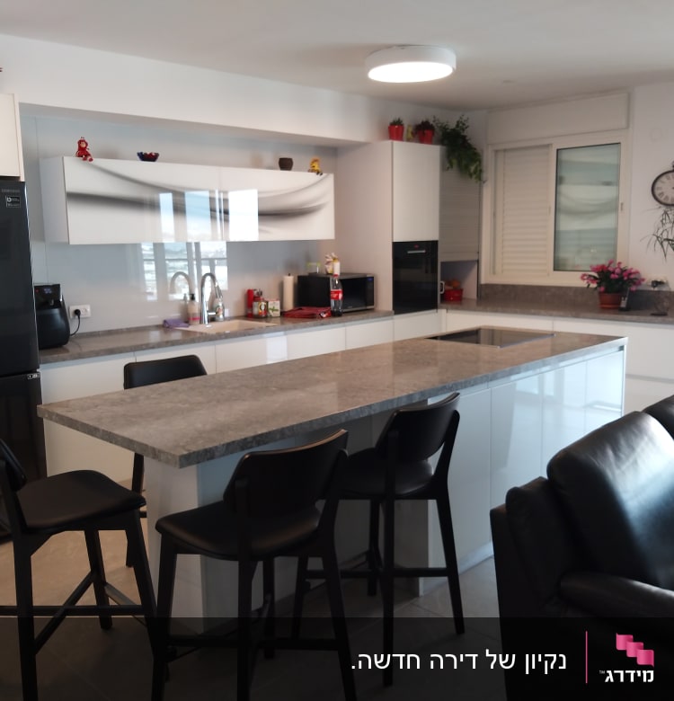 מטבח נקי עם כיור וברז, משטחי עבודה מסודרים